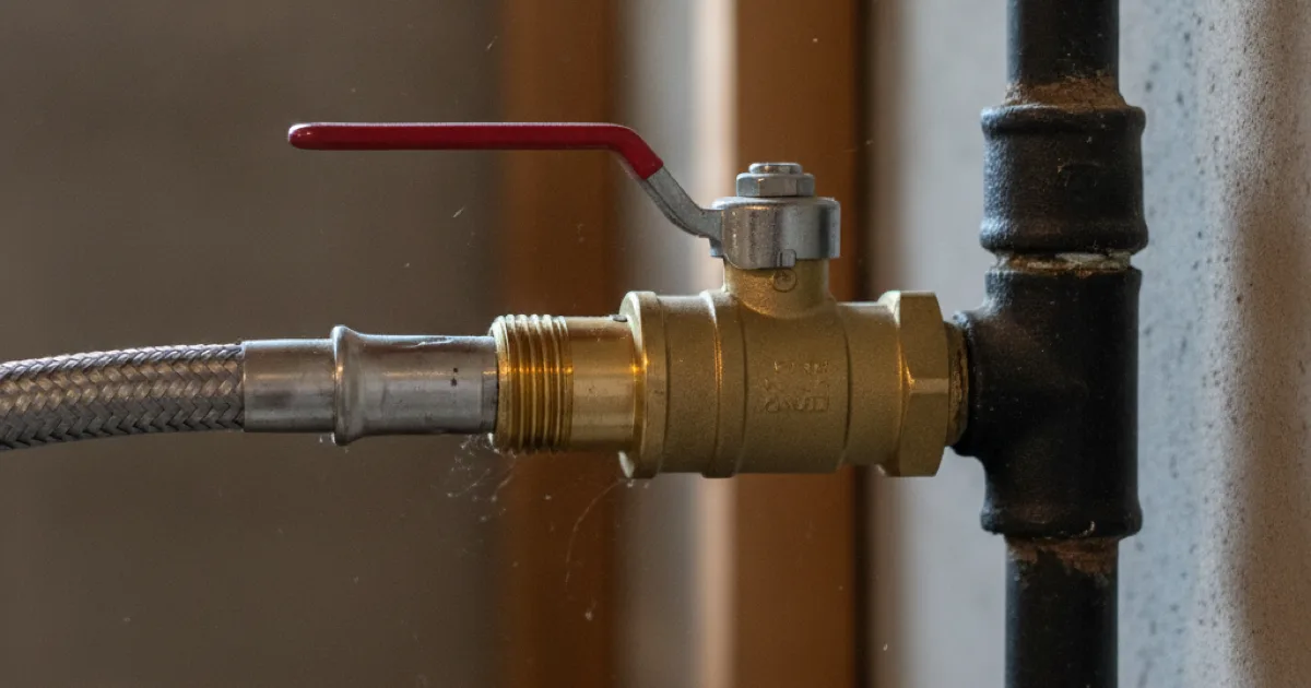 Close-up of a gas line fitting and shutoff valve